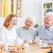 Zajęcia dla seniorów - grupa uśmiechniętych starszych osób na spotkaniu.